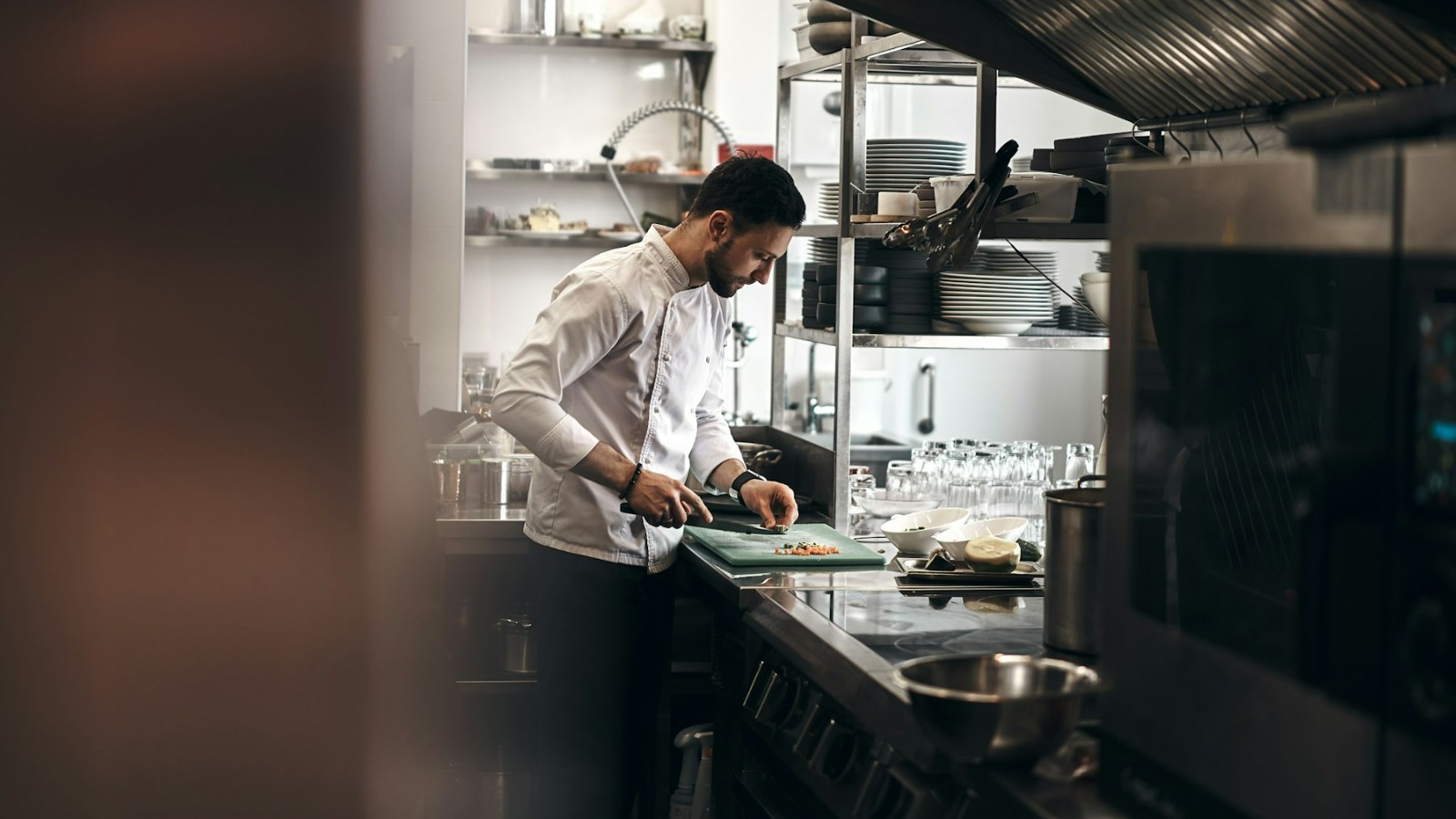 Restoran mutfağında hazırlık tezgâhında çalışan aşçı
